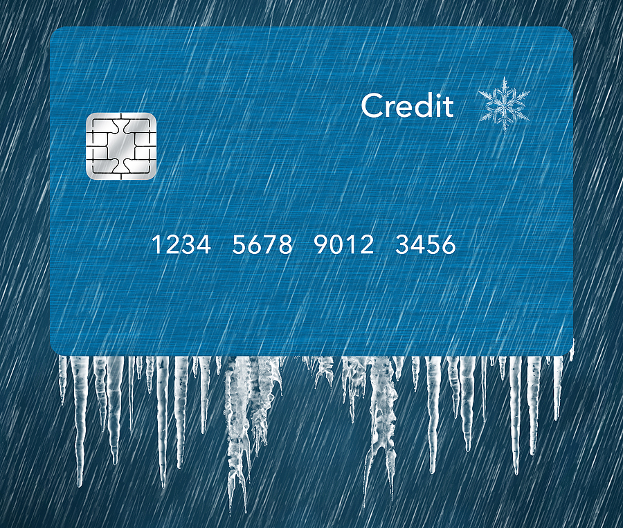 A generic blue credit card is seen in a snowstorm with icicles in a 3-d illustration about putting a credit freeze on a credit report. Bold Vision Financial