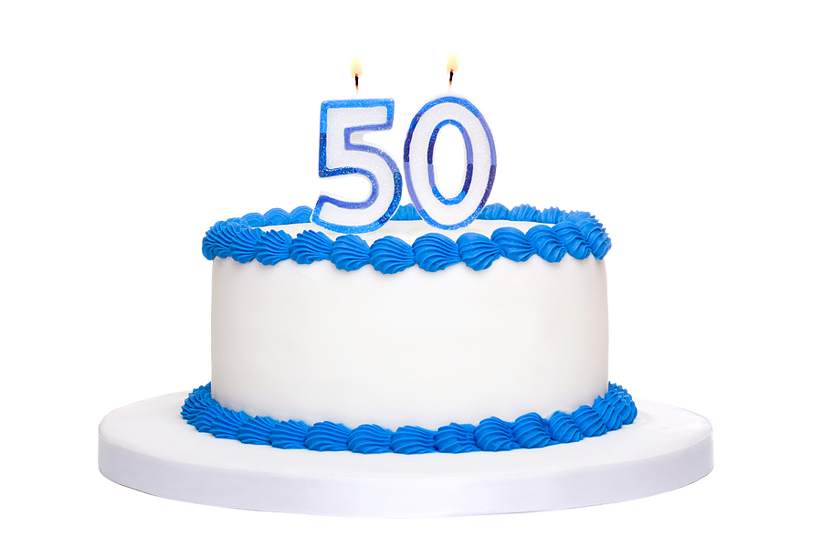 Birthday cake decorated with blue frosting and number fifty candles-BoldVisionFinancial